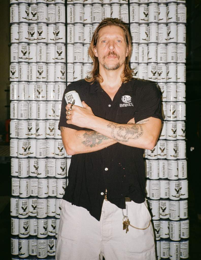 Erik Ellington holding his new non-alcoholic beer, Easy Does It Lager