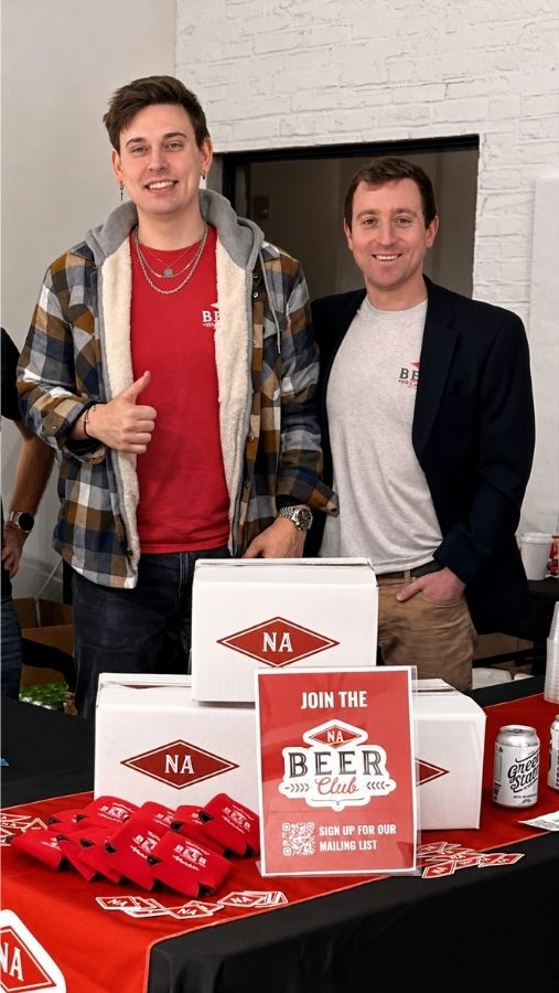 Mark Ruf and Tyler Keough of NA Beer Club standing at a table